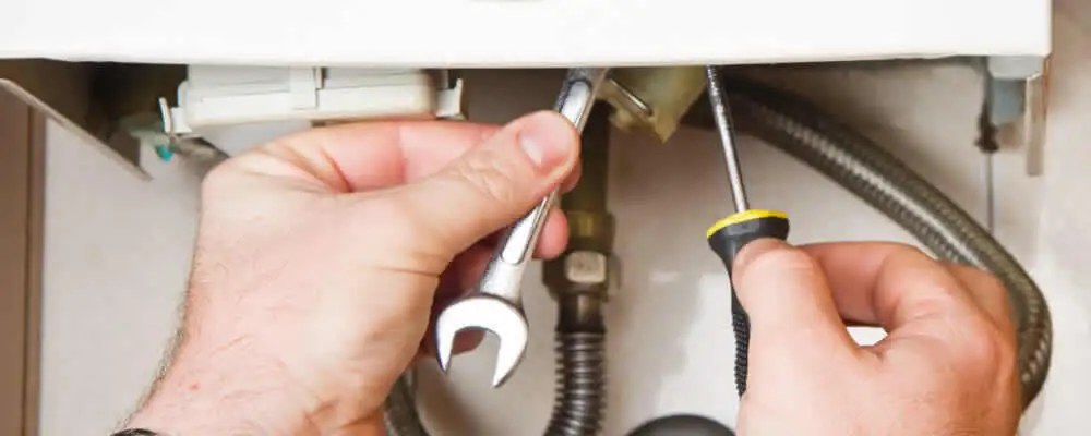 Boiler repair technician tightening pipe fittings and connections in Austin, TX