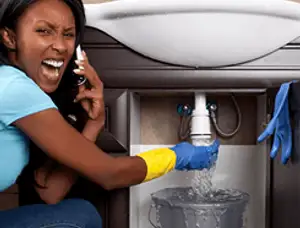 Emergency plumbing repair for a leaking sink drain under a bathroom vanity in Austin, TX