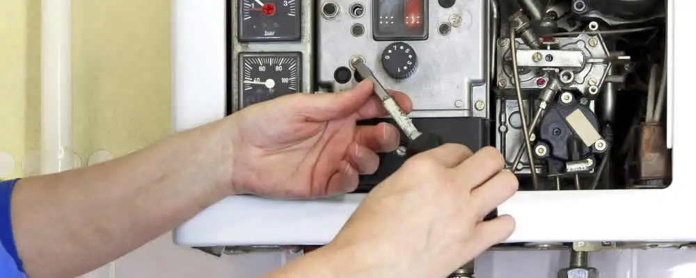 Heating repair technician adjusting boiler controls and components in Austin, TX