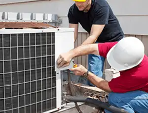 HVAC technicians repairing an outdoor AC unit on a rooftop in Austin, TX
