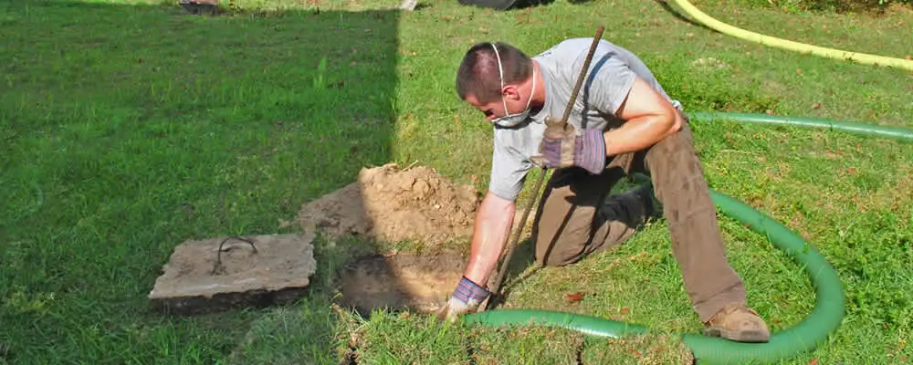 Septic pumping technician servicing a residential septic tank in Austin, TX
