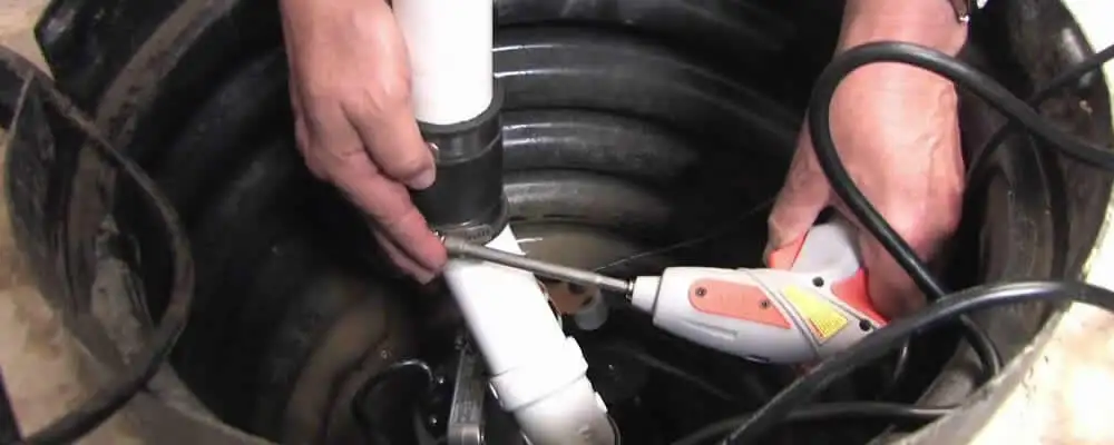 Sump pump installation technician connecting PVC discharge piping in Austin, TX