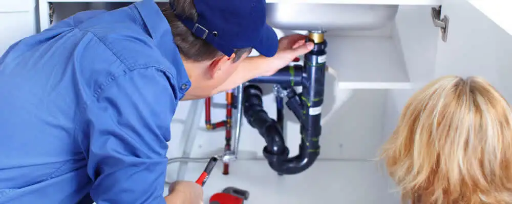 Plumber repairing under-sink drain pipes and fittings in Austin, TX